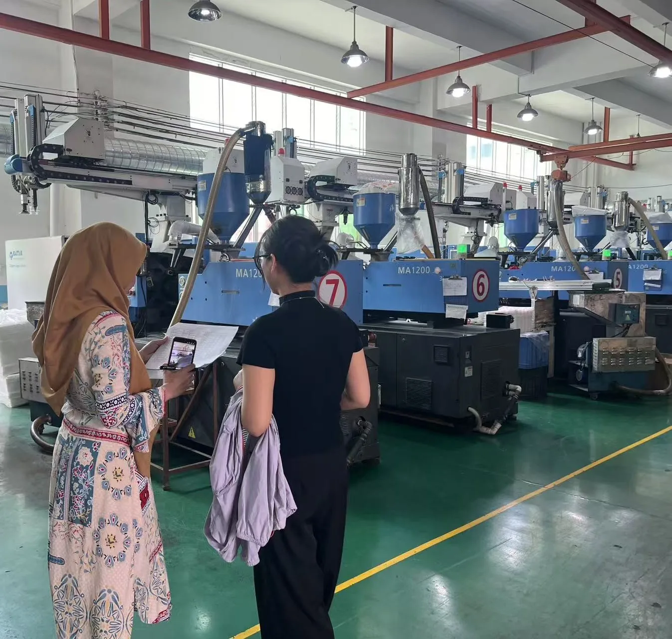 现场审核:检验机构审核员在注塑车间查看生产现场